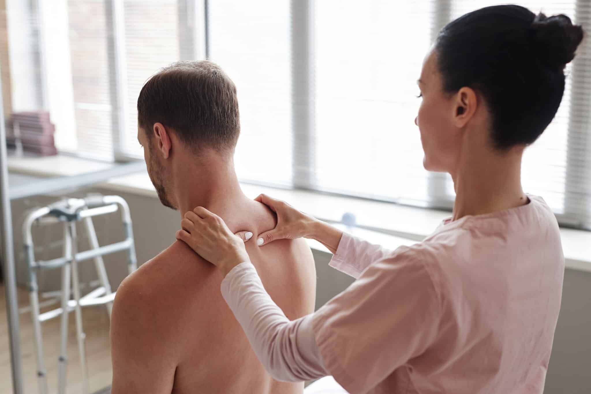 Manual therapist massaging back of patient